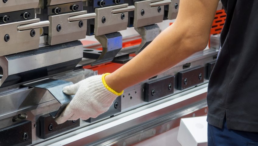 Close up of metal forming machine used by worker